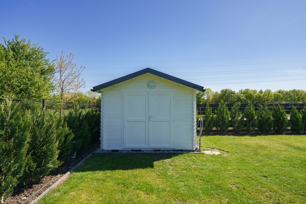 White Shed With Black Roof in a Grassy Yard — ShedBoss in Millaa Millaa, QLD 