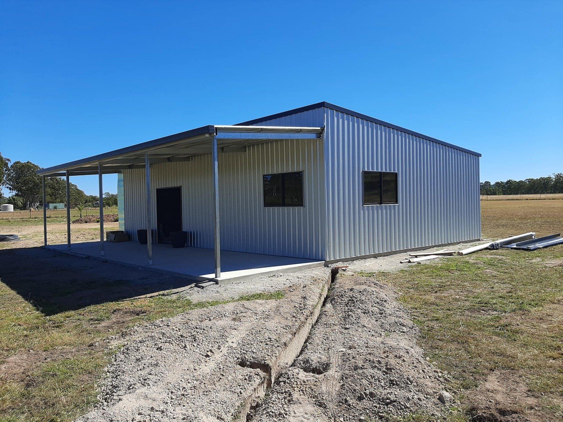 Metal Building With Covered Porch on a Grassy Field — ShedBoss in Atherton, QLD