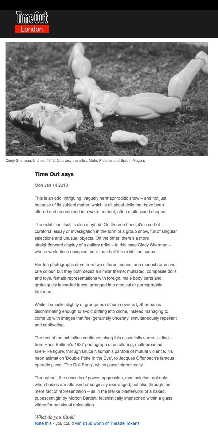 A black and white photo of two dolls laying on the ground.