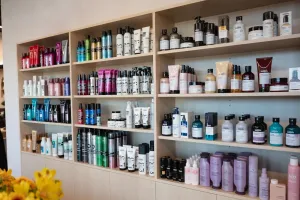 Shelves lined with assorted hair care and beauty product bottles in a salon or store.