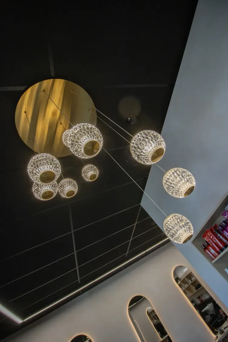 Modern ceiling with glowing spherical pendant lights and a gold circular accent panel