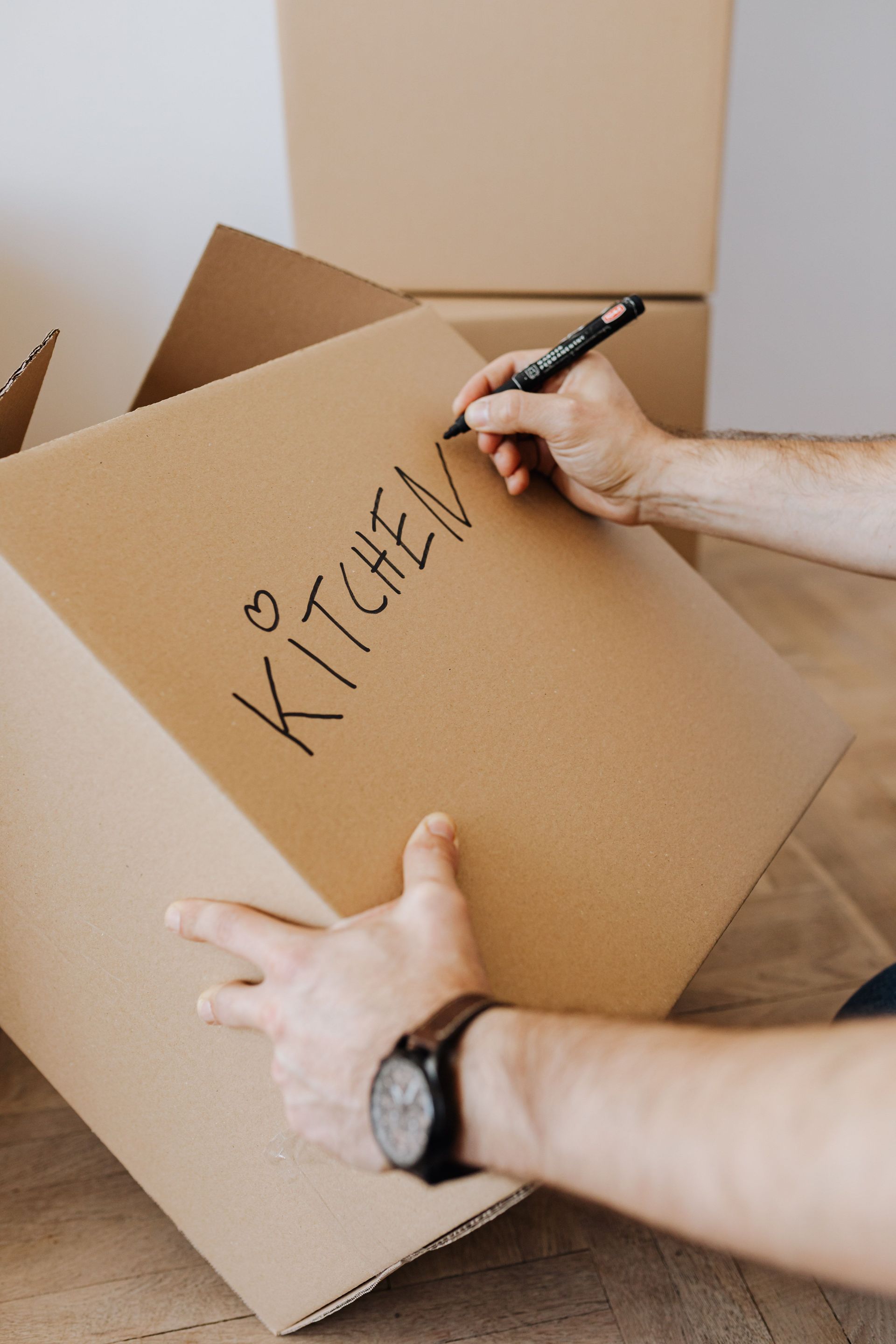 Person labels a cardboard box 