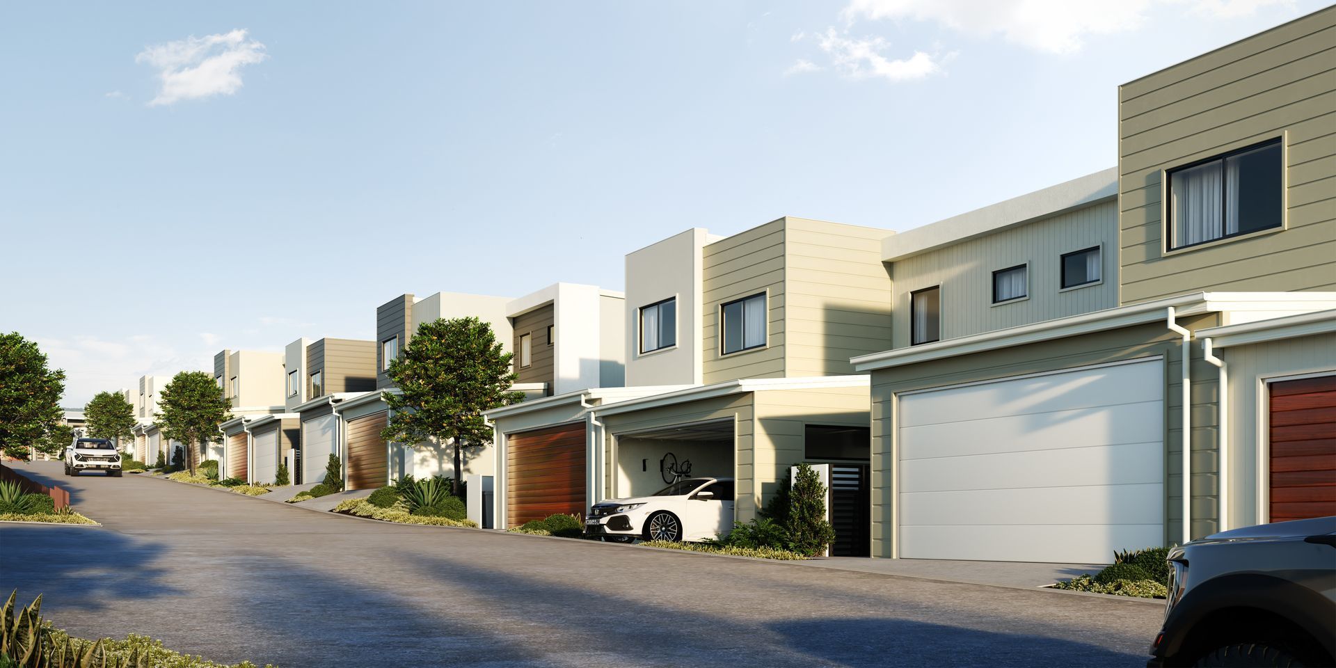 Quiet suburban street with modern townhouses, garages, and parked cars in daylight