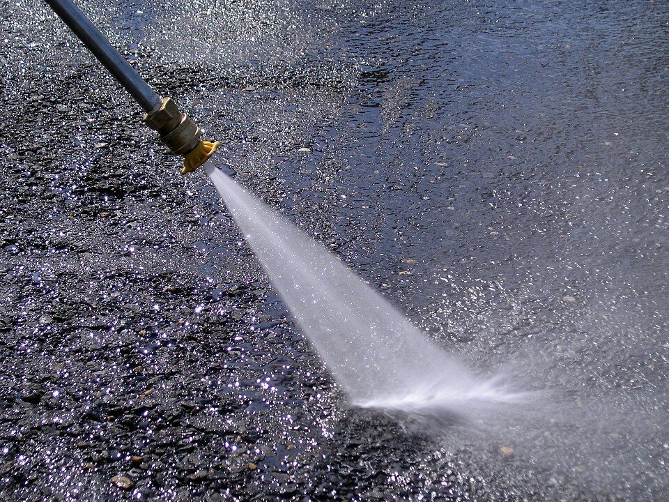 Pressure washer cleaning pavement - power washing by Hedges to Edges Lawn Care in Tampa