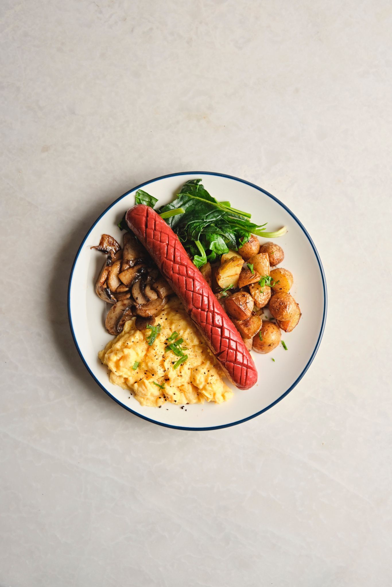 <b>frankfurter bravas</b><br>Sausage, baked baby potatoes, scrambled eggs, sautéed mushrooms, Aegean herbs (750 gr.)