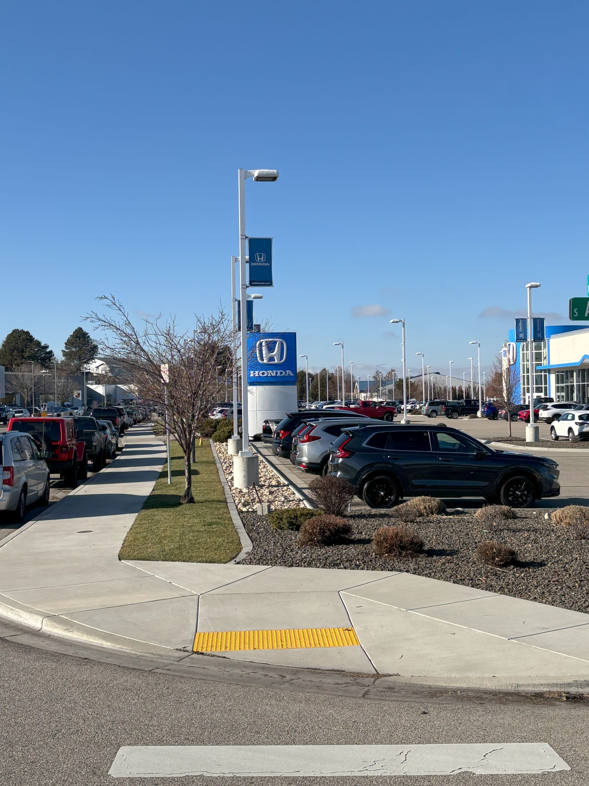 A lot of cars are parked in front of a honda dealership