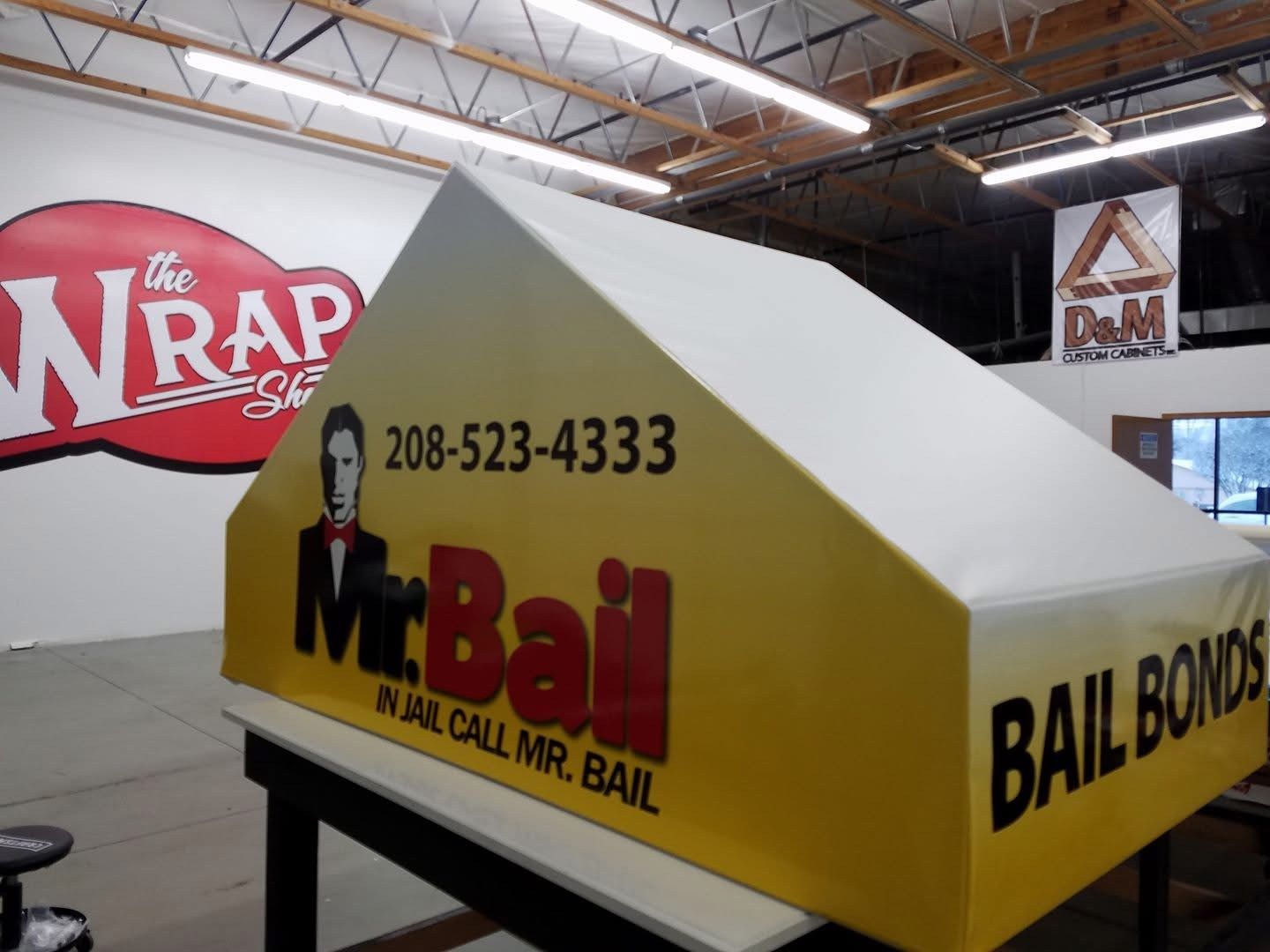 A yellow and white sign that says mr. bail bail bonds