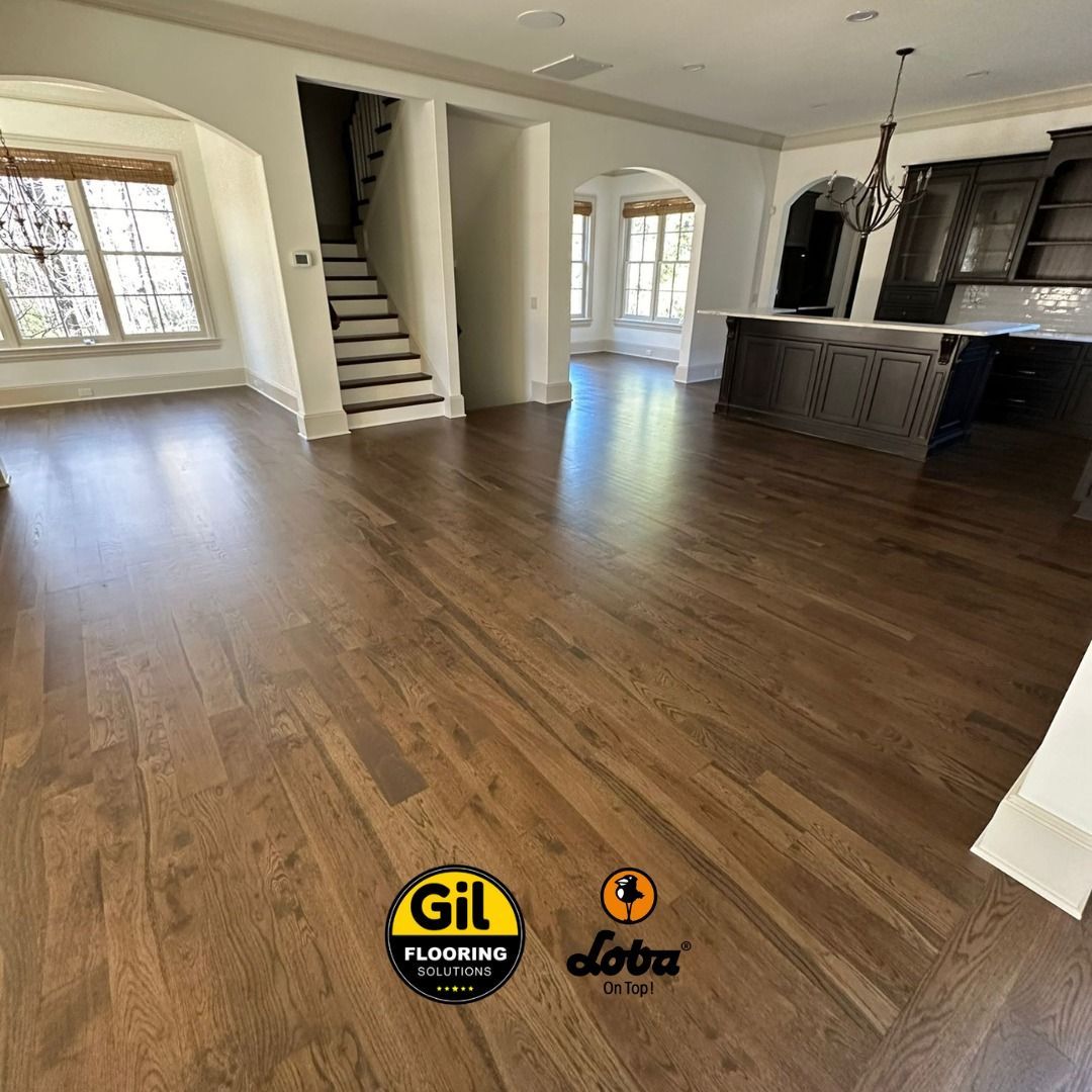 A living room with hardwood floors and stairs in a house. A living room with hardwood floors and stairs in a house.
