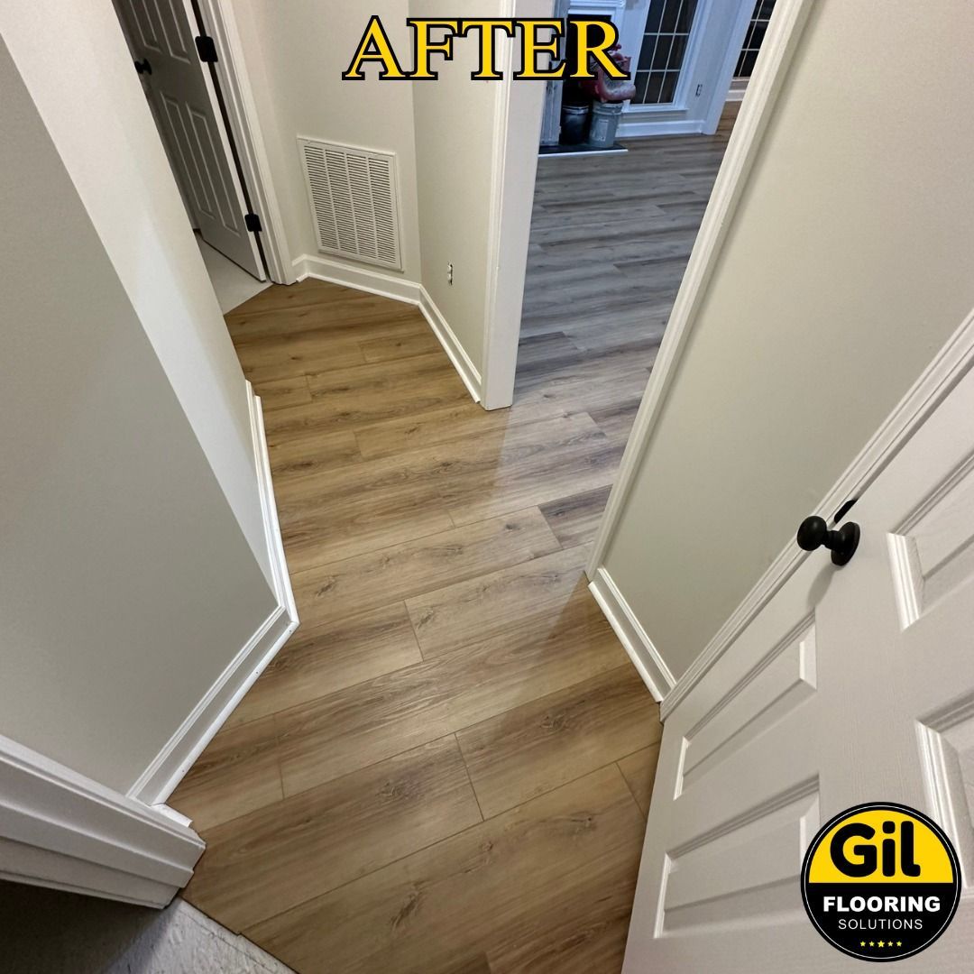 A hallway with a wooden floor and white trim.