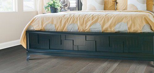 A bedroom with a bed and a bench on the floor.