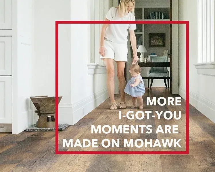 A woman and a child are walking down a hallway.