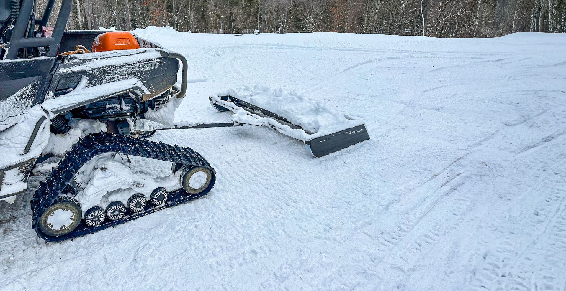 A snow plow pulling a 60 inch trail groomer