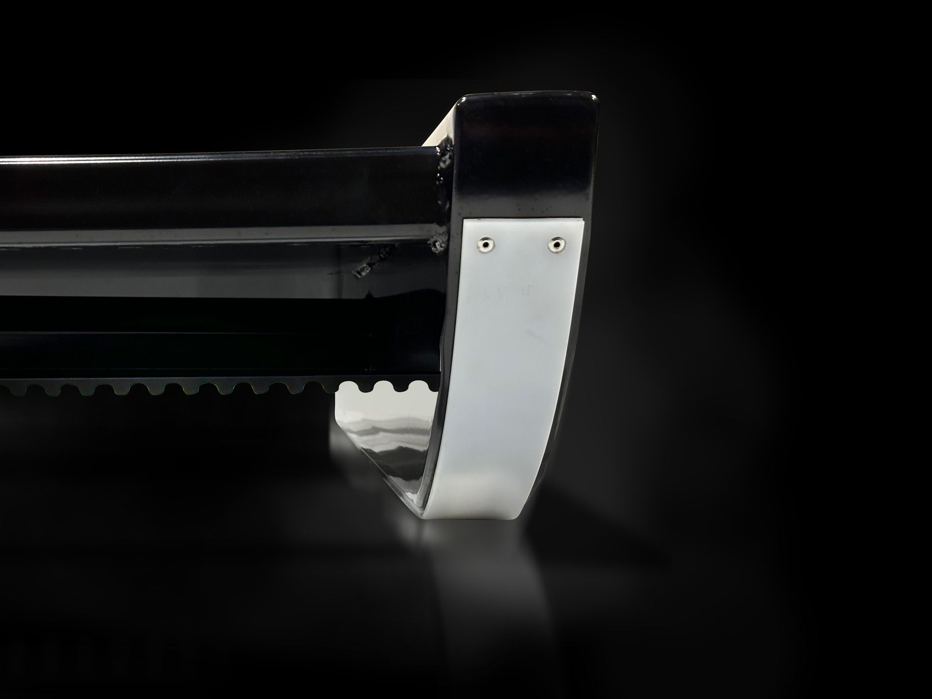 A close up of a metal object on a black background