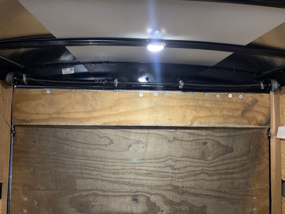 Inside a wooden cabinet, a bright LED light illuminates the top hinge and shelves.