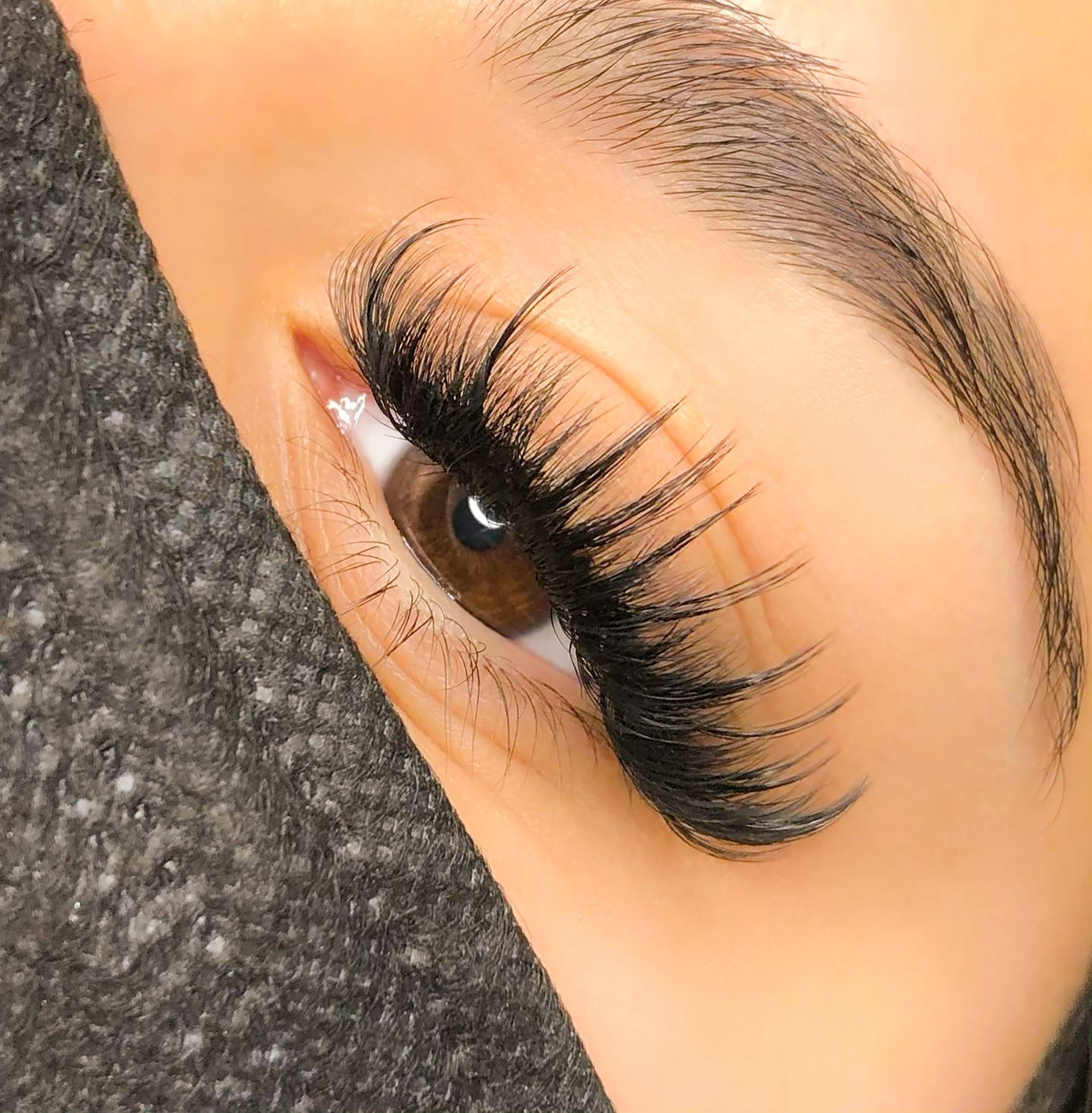 A close up of a woman 's eye with long eyelashes.