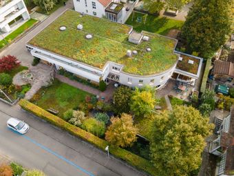 Man sieht die Werkstube in Aesch. Ein begründets Haus, mit einem tollen Garten.
