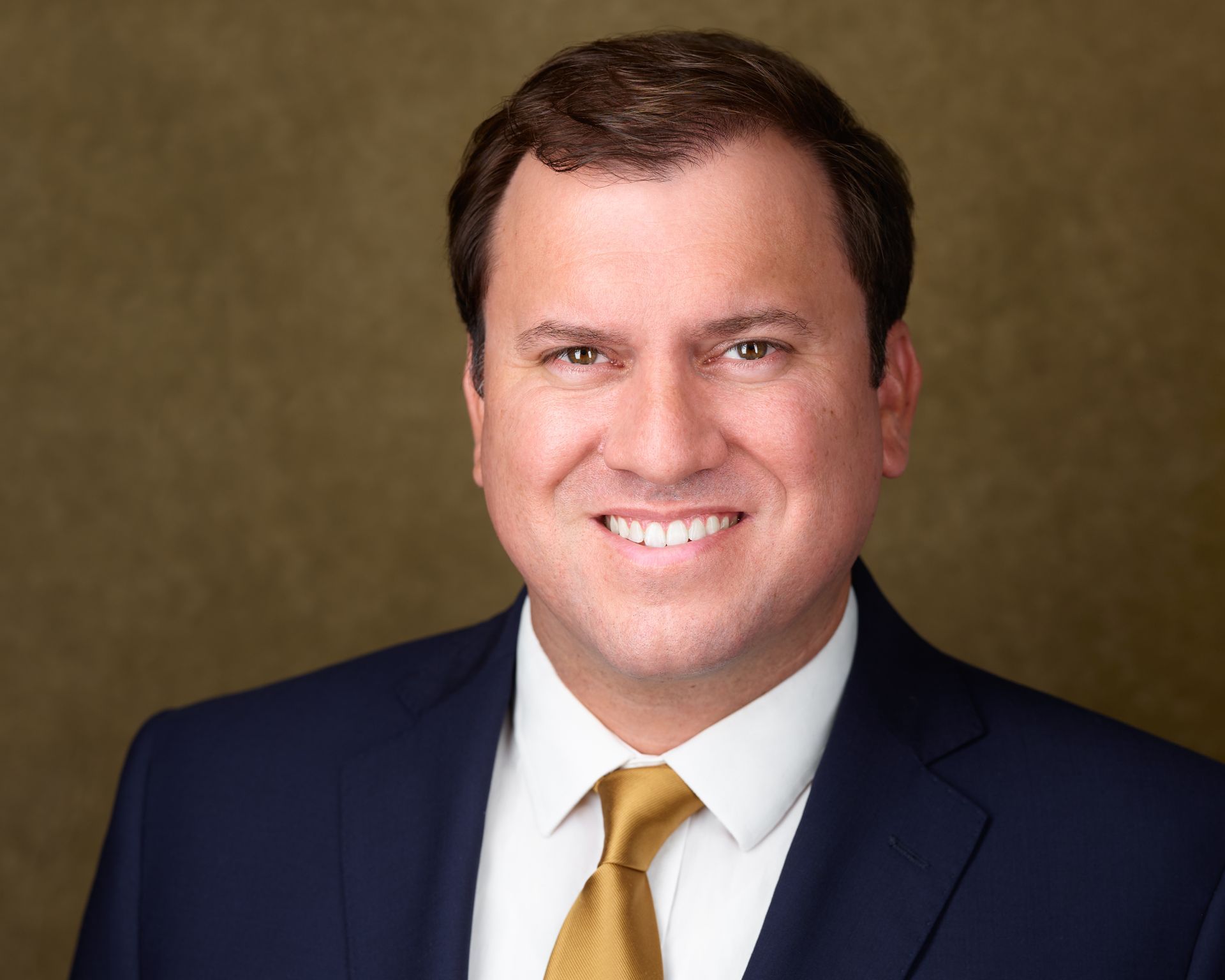 A man in a suit and tie is smiling for the camera.