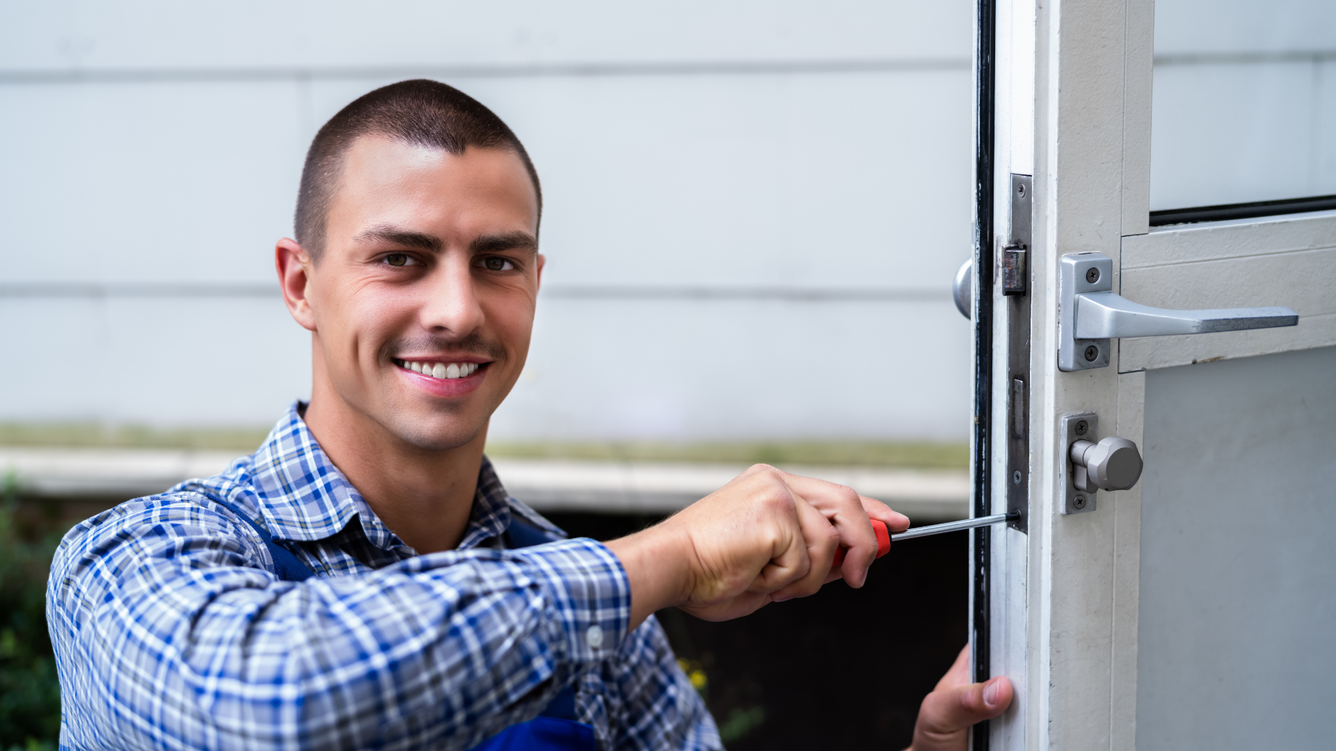 A man is fixing a door with a screwdriver.
