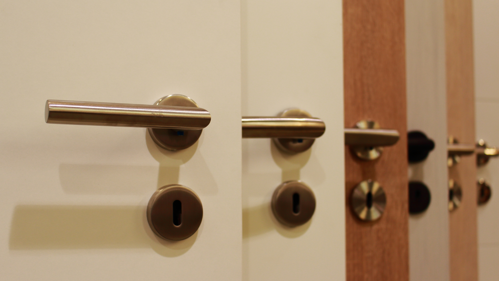 A row of door handles are lined up on multiple doors.