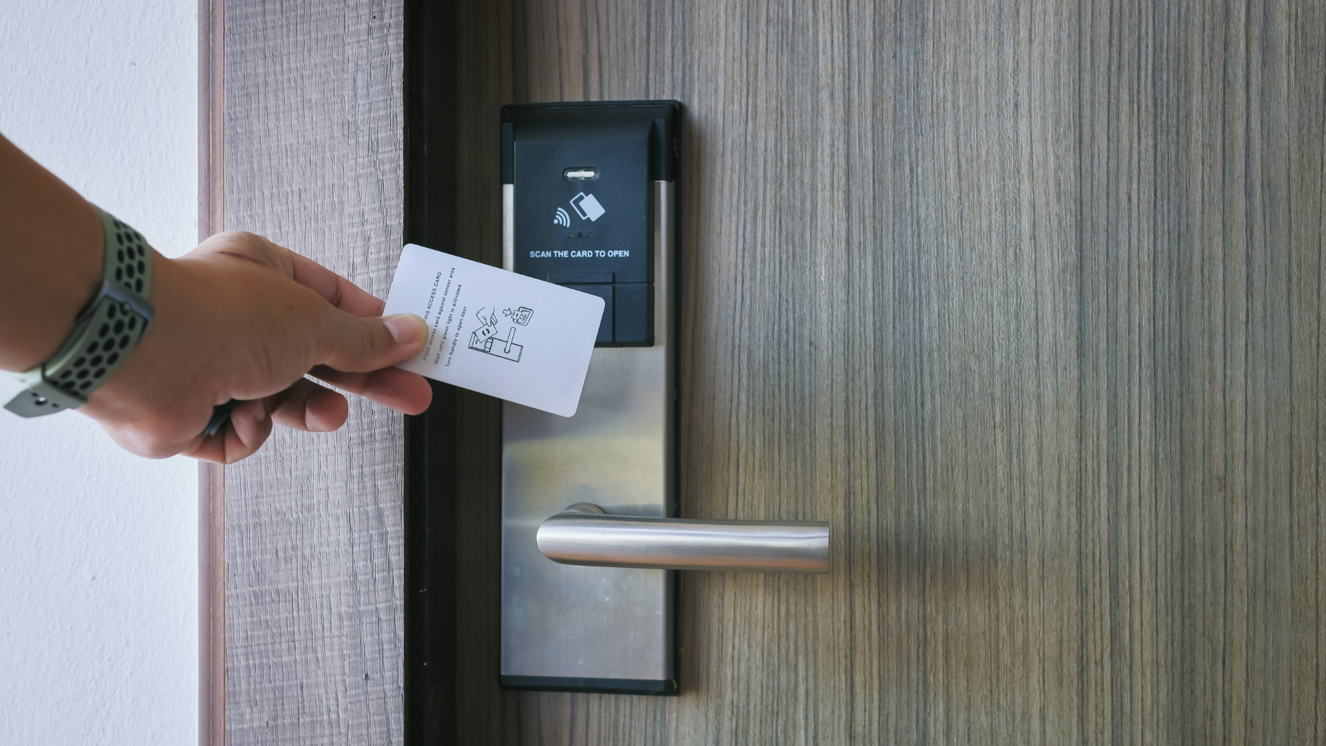 A person is inserting a key into a hotel door lock.