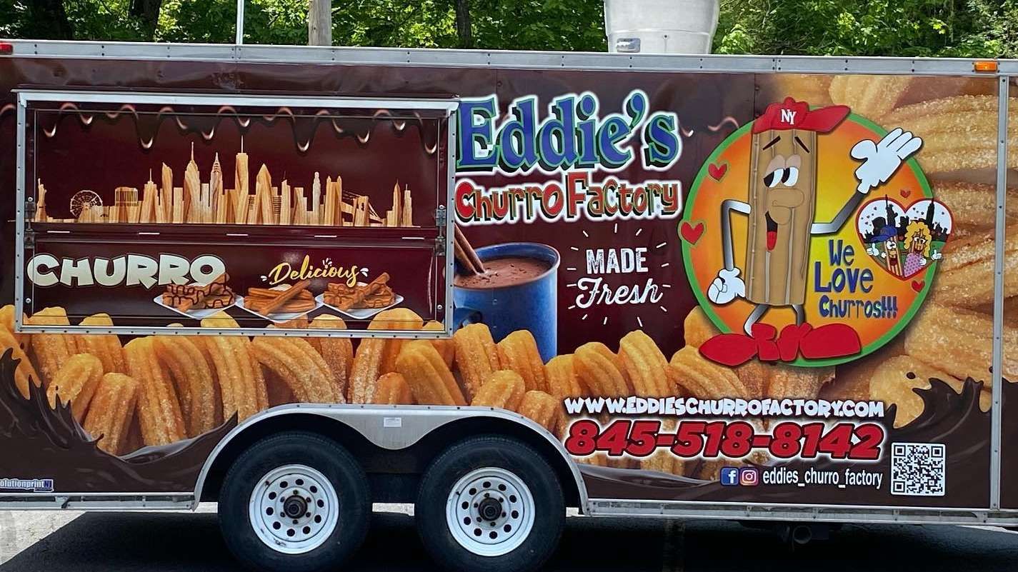 Eddie's Chimney cleanup trailer with flames, brick chimney graphic, and contact info on orange background