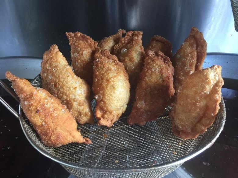 Golden-brown fried pastries resting on a wire rack, fresh from the fryer