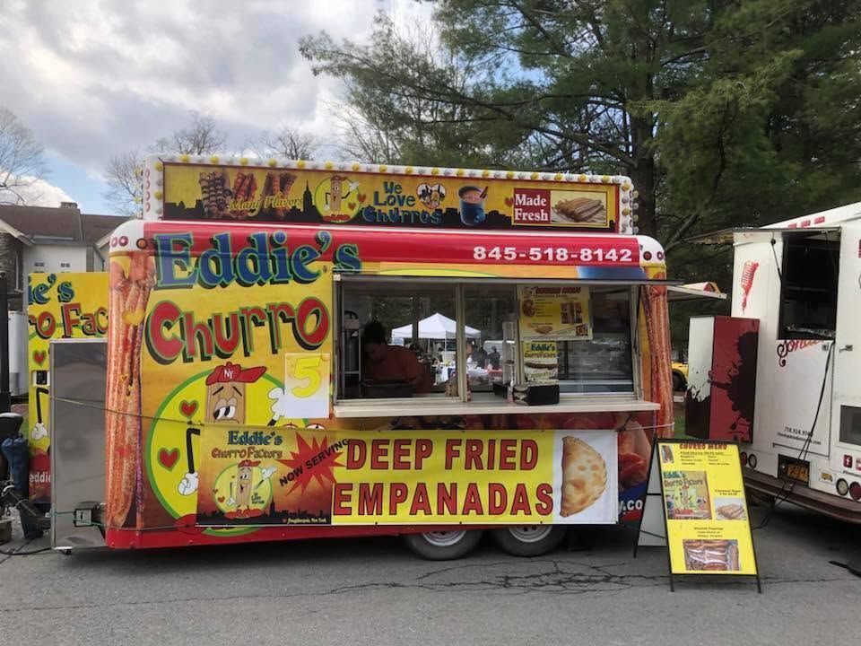 Bright yellow Eddie Churro food truck serving deep-fried empanadas at an outdoor market