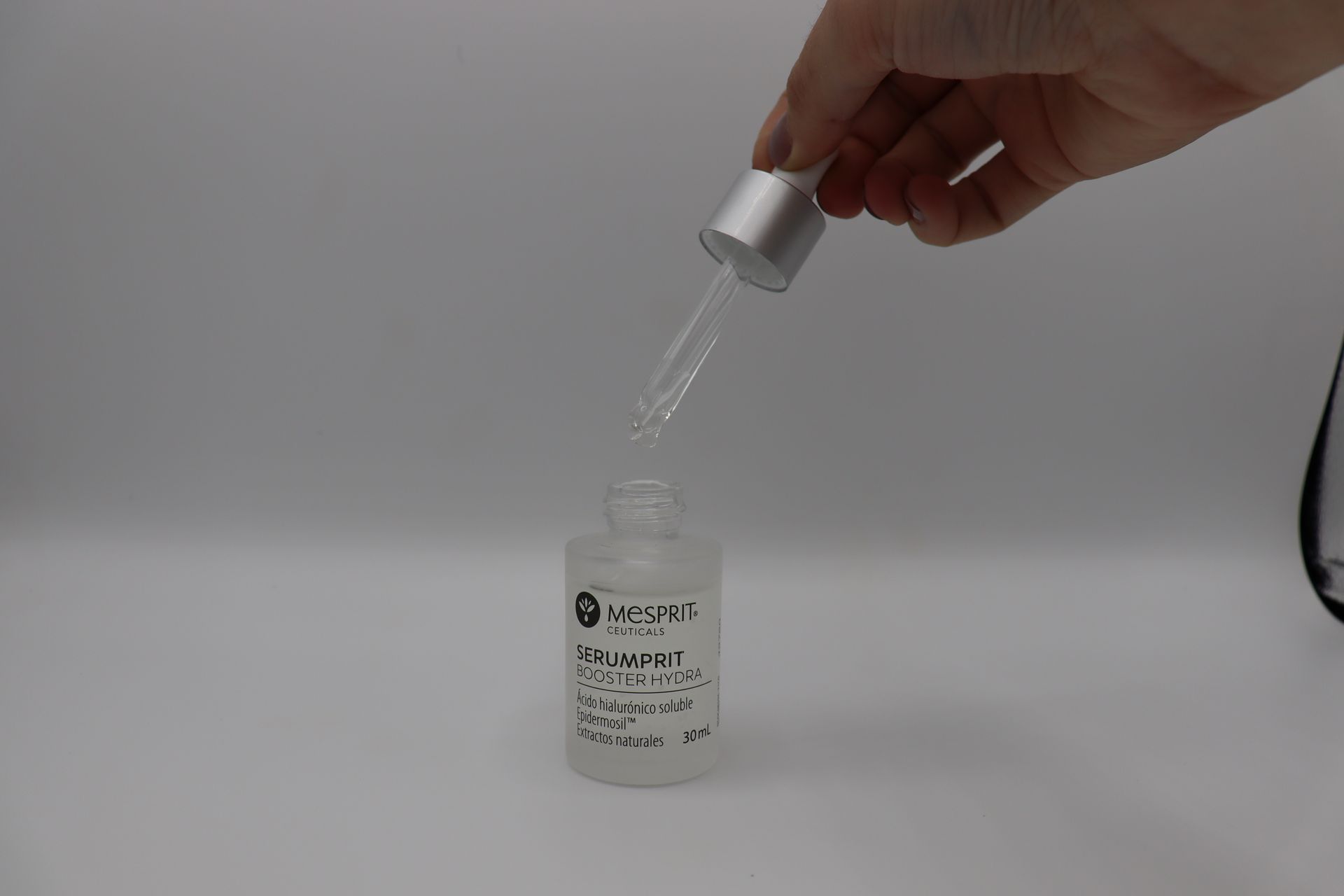 Una persona sostiene una pipeta sobre una botella de líquido.
