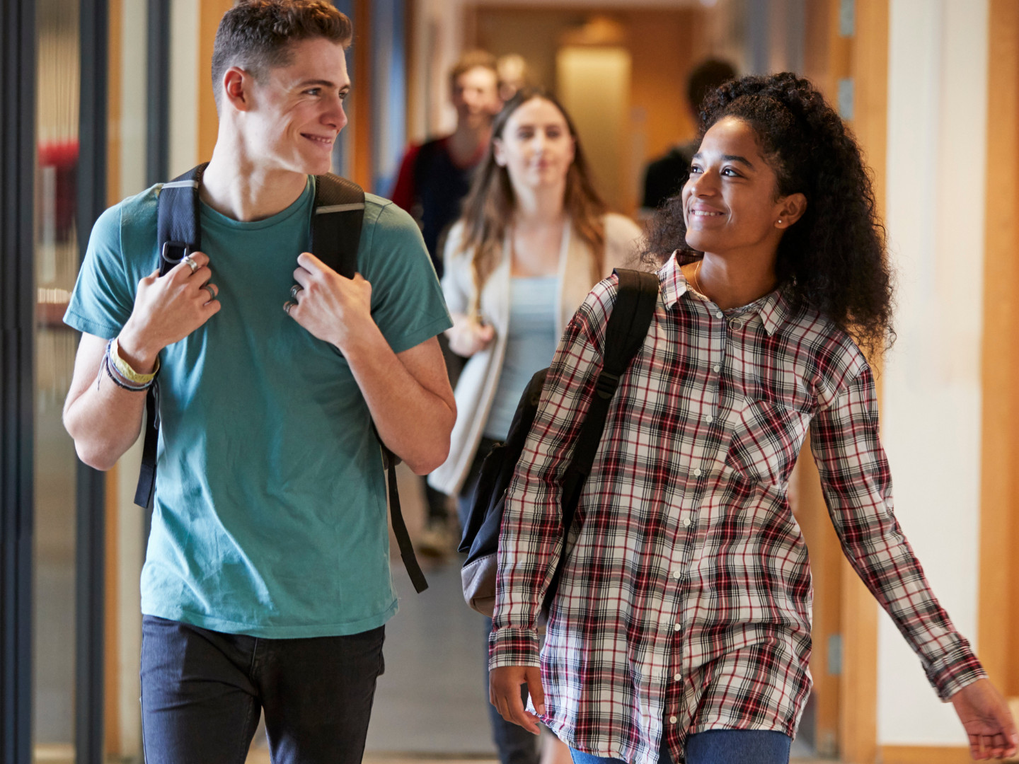 Male and female walking through a school hallway