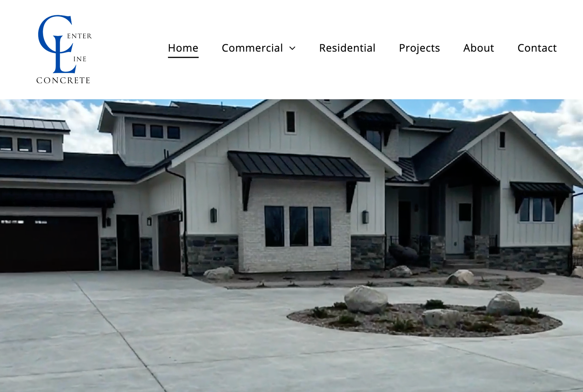 Modern gray house with a large driveway and landscaped front yard