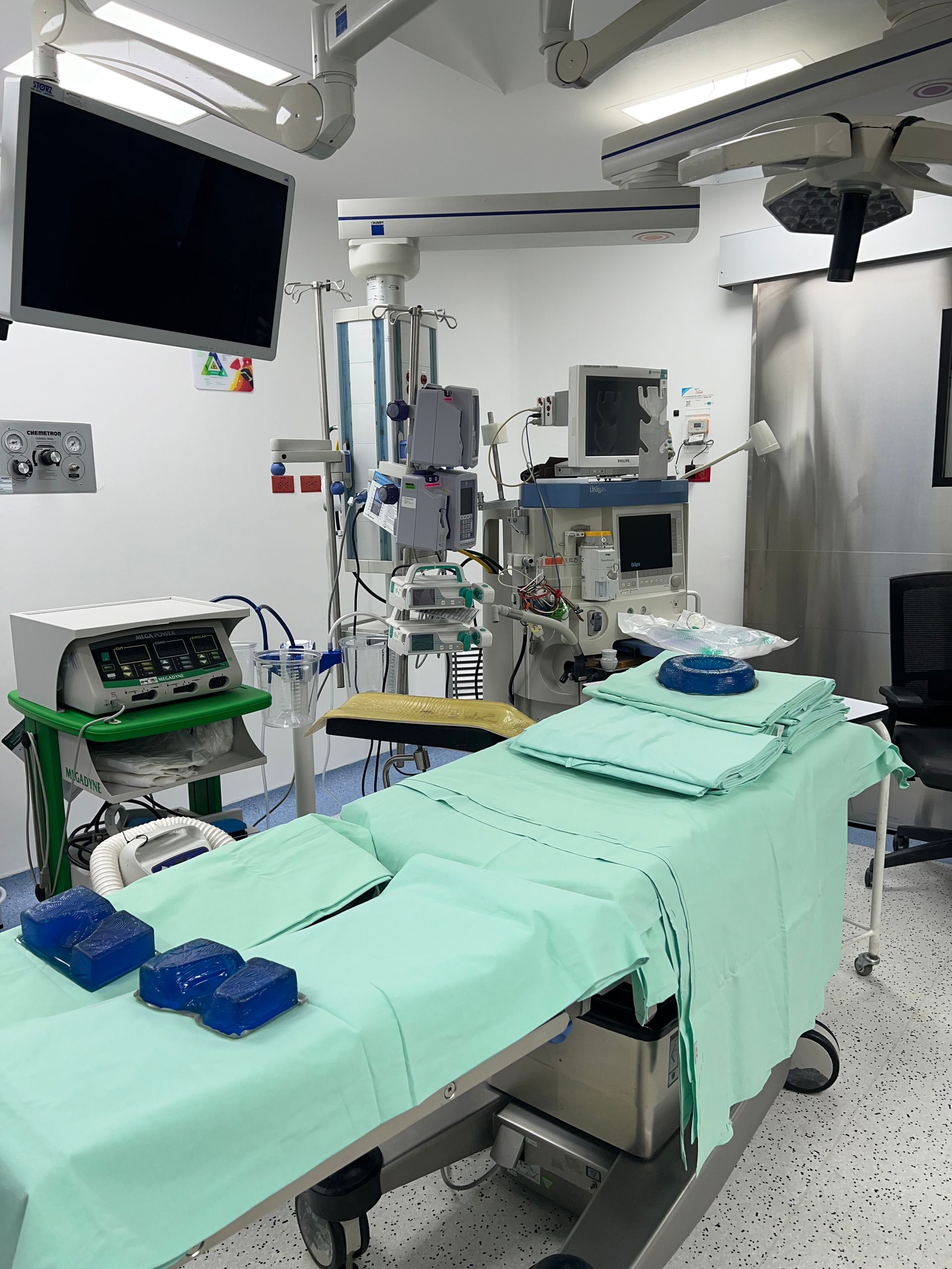 Un quirófano con una cama y monitores en el techo.