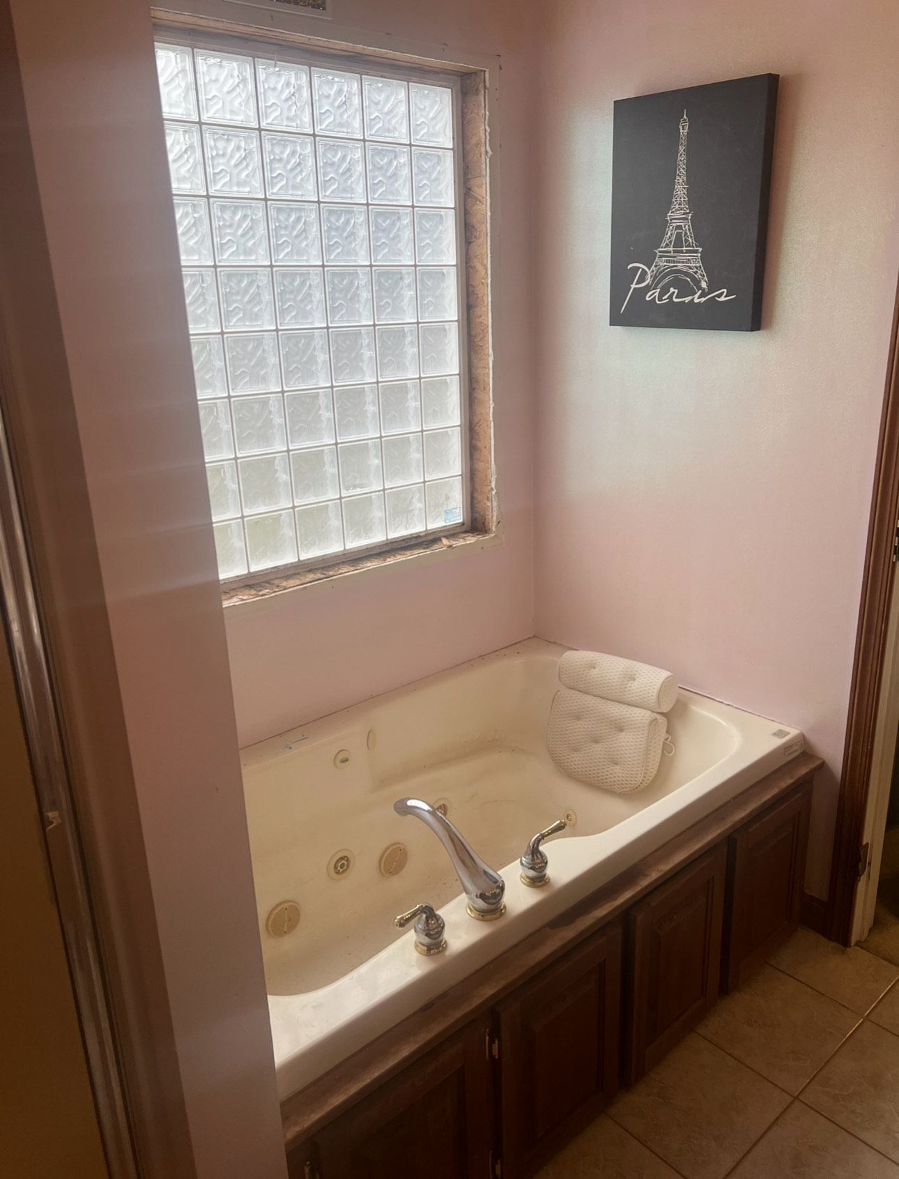 A bathroom with a jacuzzi tub and a picture of the eiffel tower on the wall.