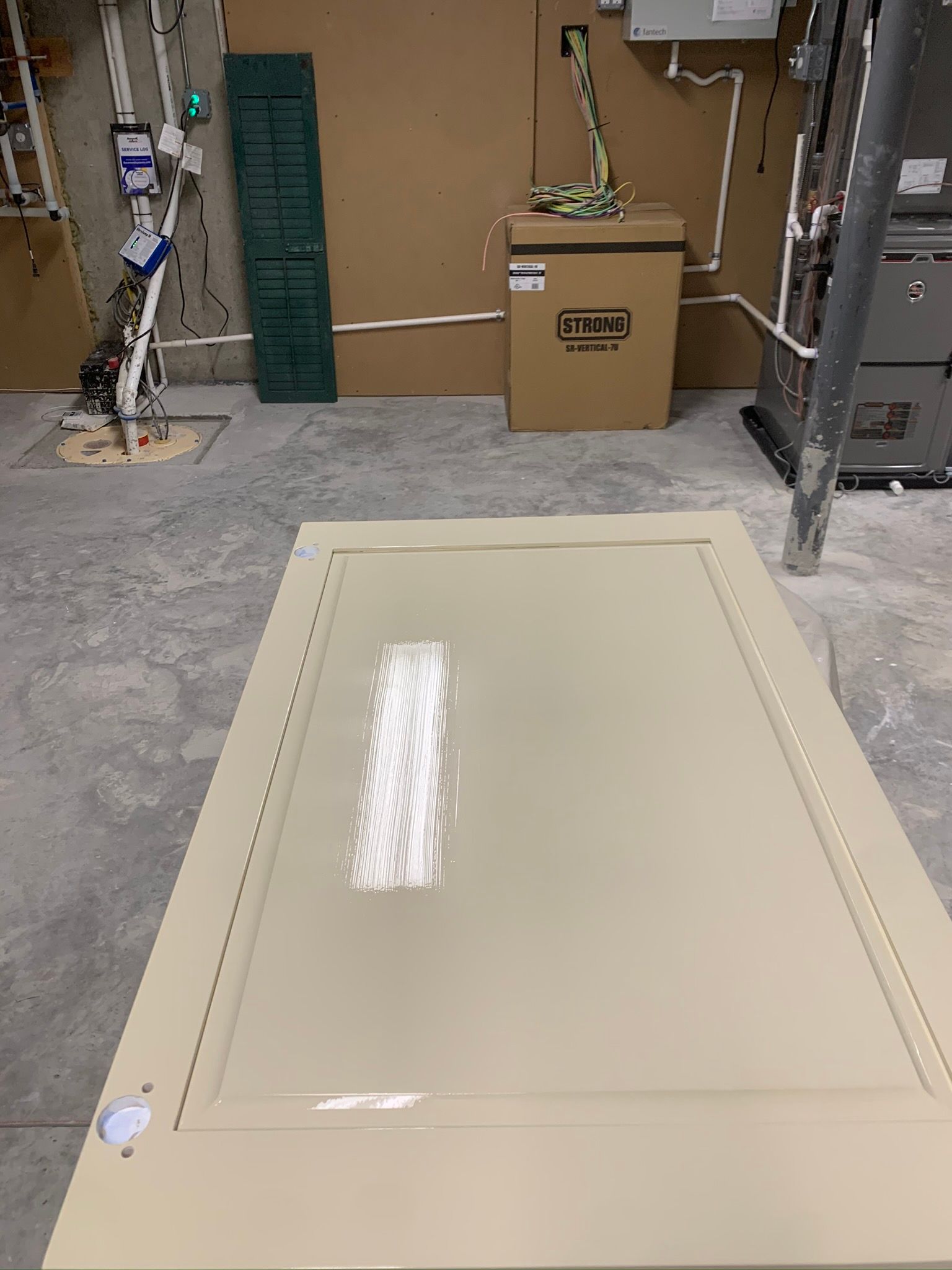 Industrial room with a beige metal panel lying on the floor and shelving on both sides