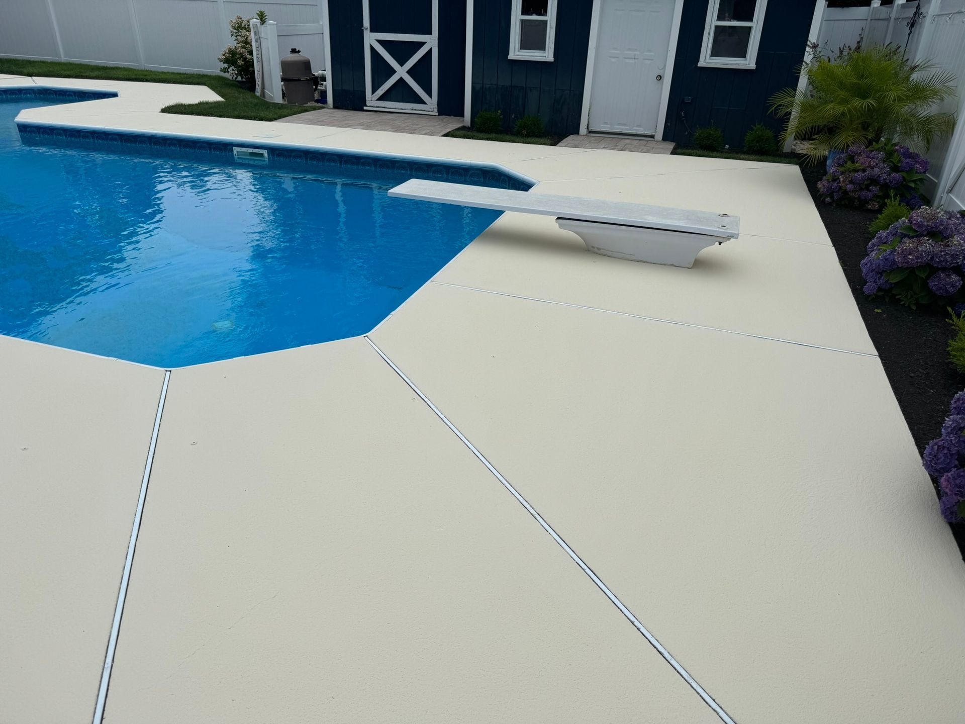 Backyard pool with white safety cover, blue water, and a house in the background