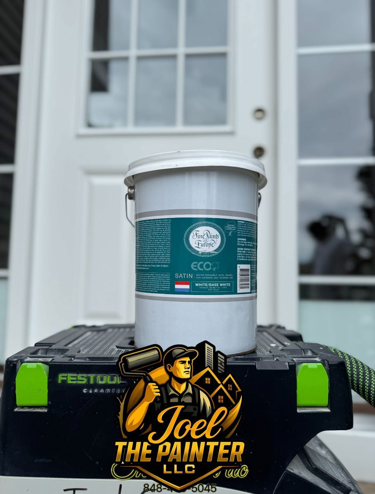 White paint bucket on a Festool box in front of a house door