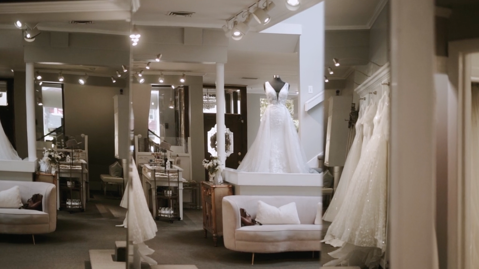 Bride and groom embrace in desert landscape; groom kisses bride's cheek; she smiles.