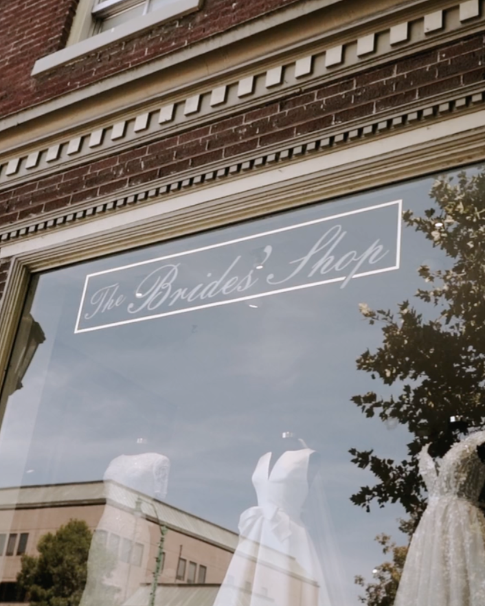 Couple in wedding attire embrace in snowy forest; bride holds bouquet.