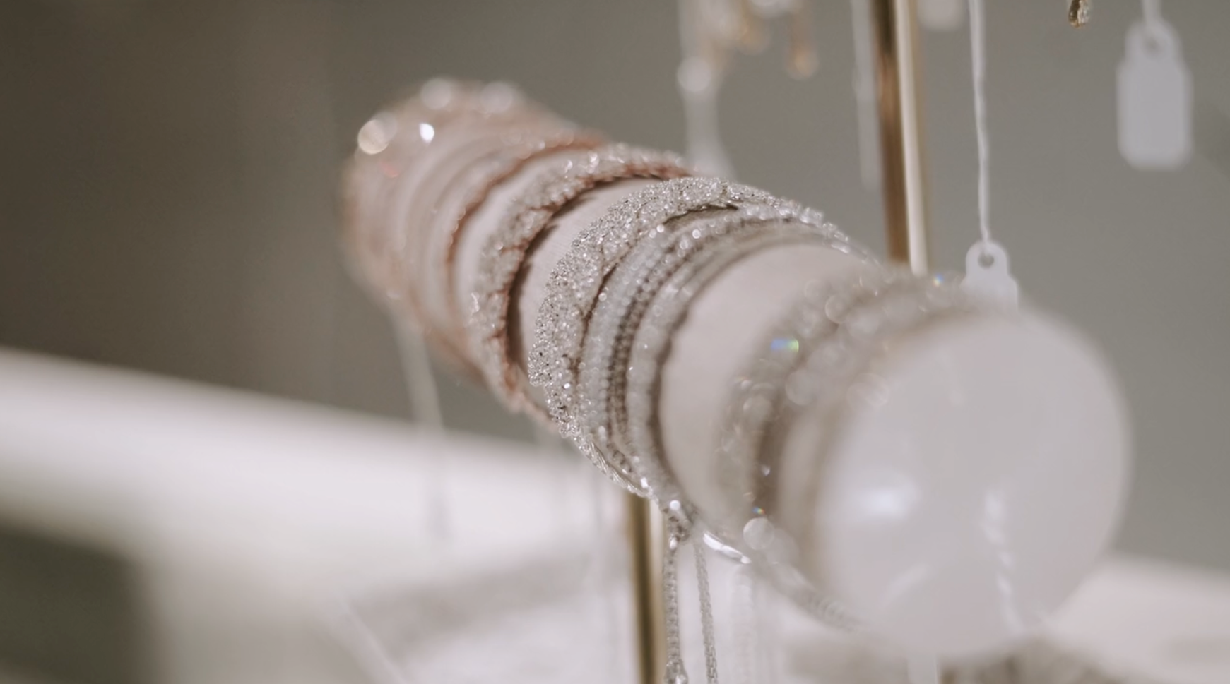 Bracelets of varying colors on display stand, including silver and tan.