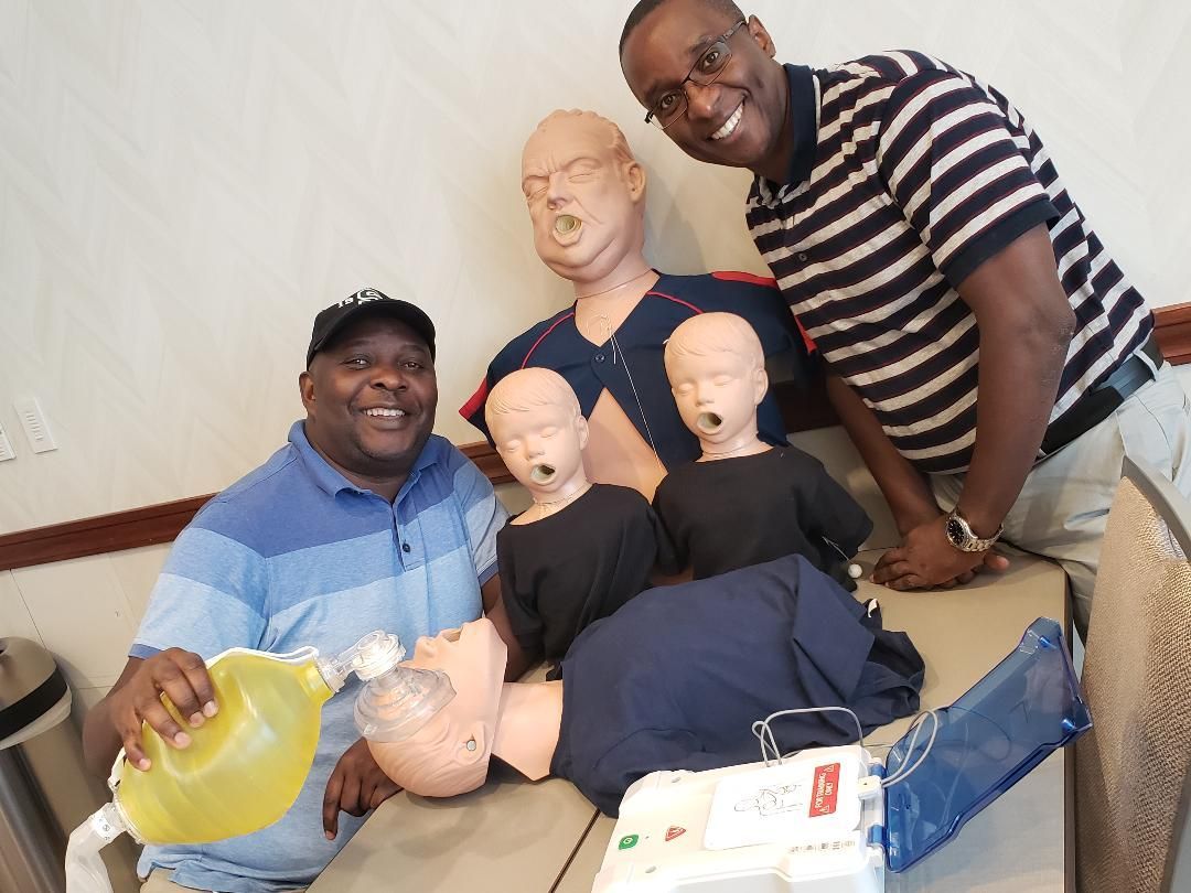 Three people pose with mannequin heads and a yellow bowl in a room.