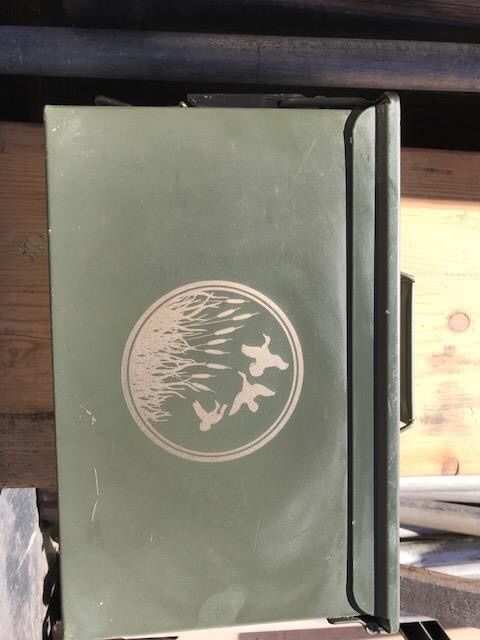 Green folder with circular bird logo on a wooden surface, viewed from above