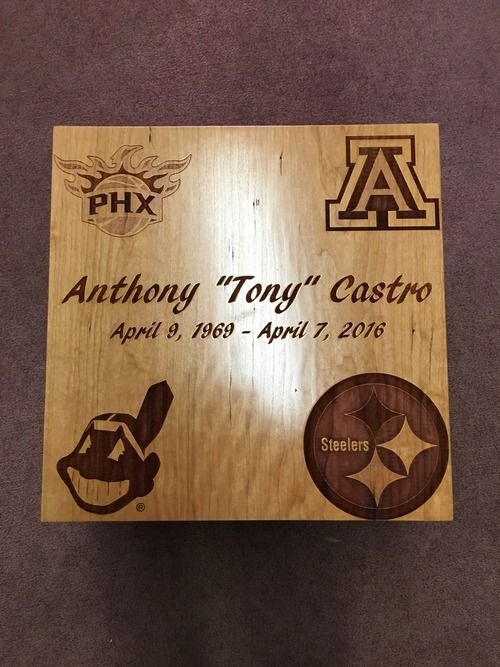 Wooden memorial plaque for Anthony “Tony” Castro with sports team logos and dates April 6, 1950–April 7, 2016.