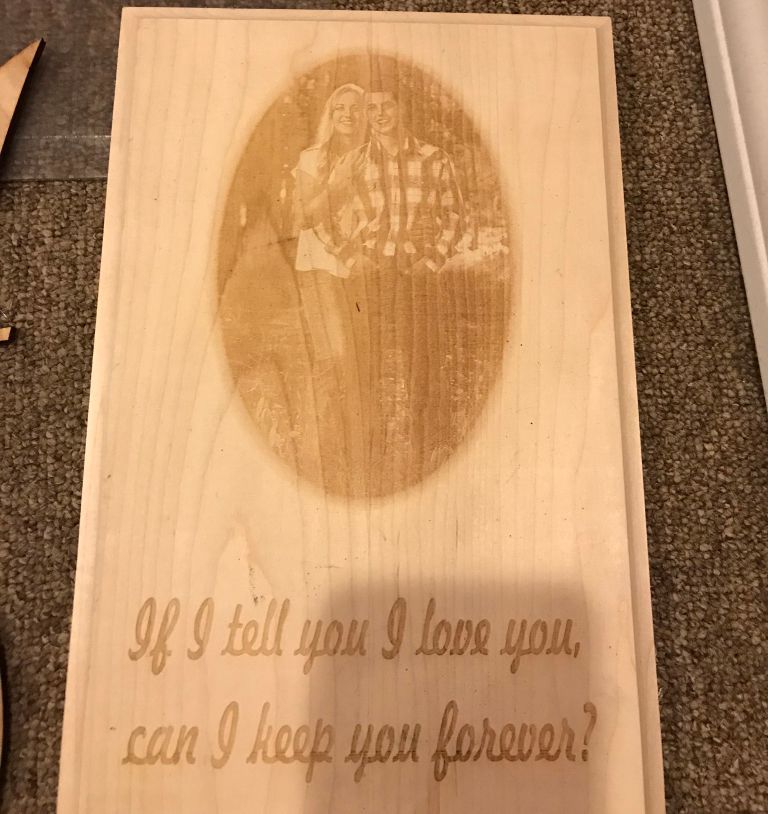 Wooden plaque with engraved oval portrait and the quote, “If I tell you I love you, can I keep you forever?”