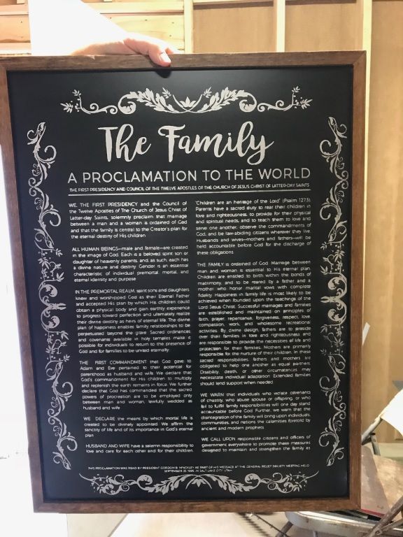 Framed black poster titled “The Family: A Proclamation to the World” with white decorative text and border