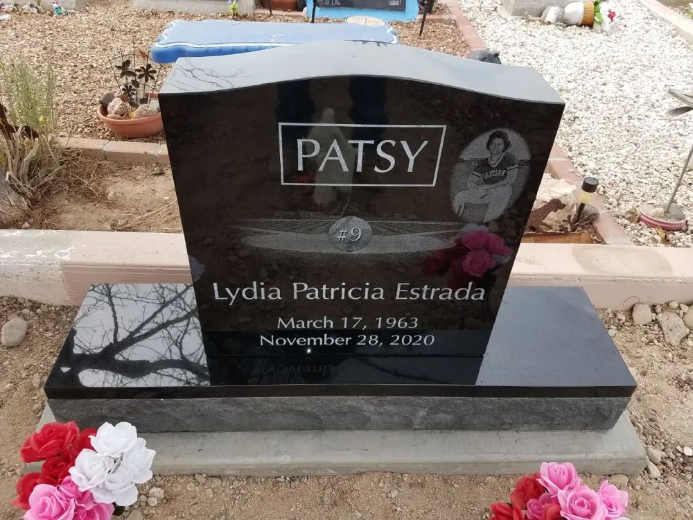 PATSY gravestone with flowers, black marble marker in a cemetery, engraved with dates and photo portrait
