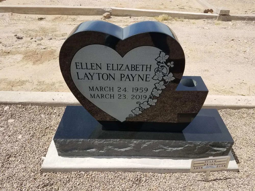 Black heart-shaped gravestone for Ellen Elizabeth Layon Payne in a sandy cemetery.
