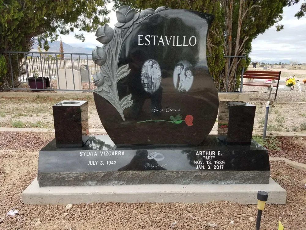 Black granite memorial headstone engraved “ESTAVILLO” with two portrait photos, in a cemetery.
