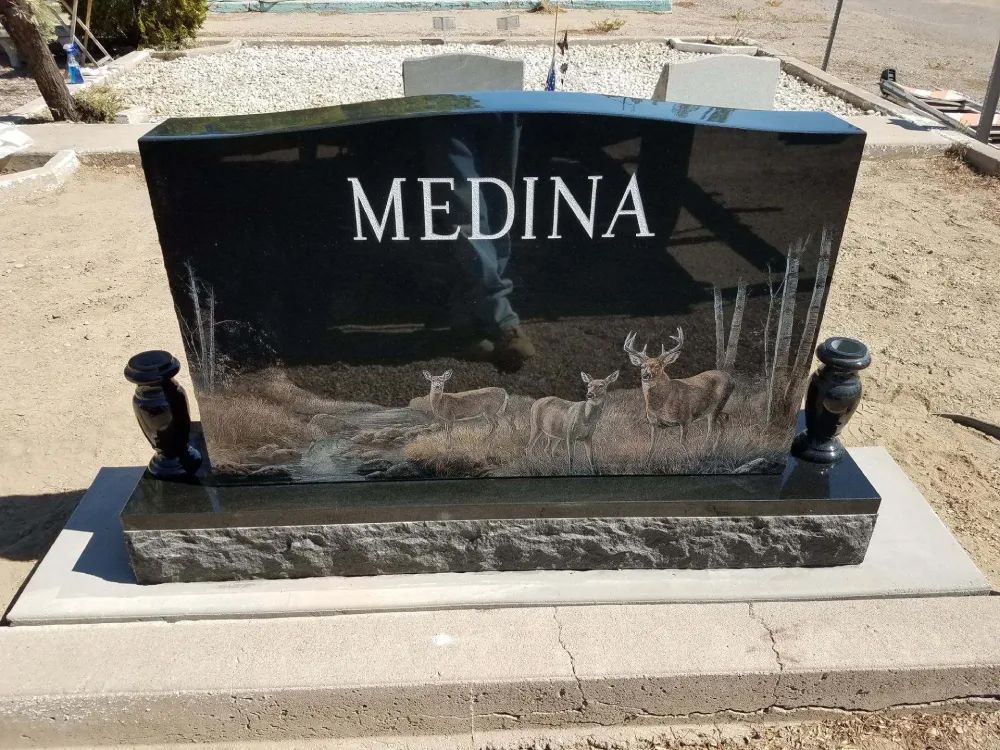 Black granite grave marker engraved “MEDINA” on a concrete base in a cemetery
