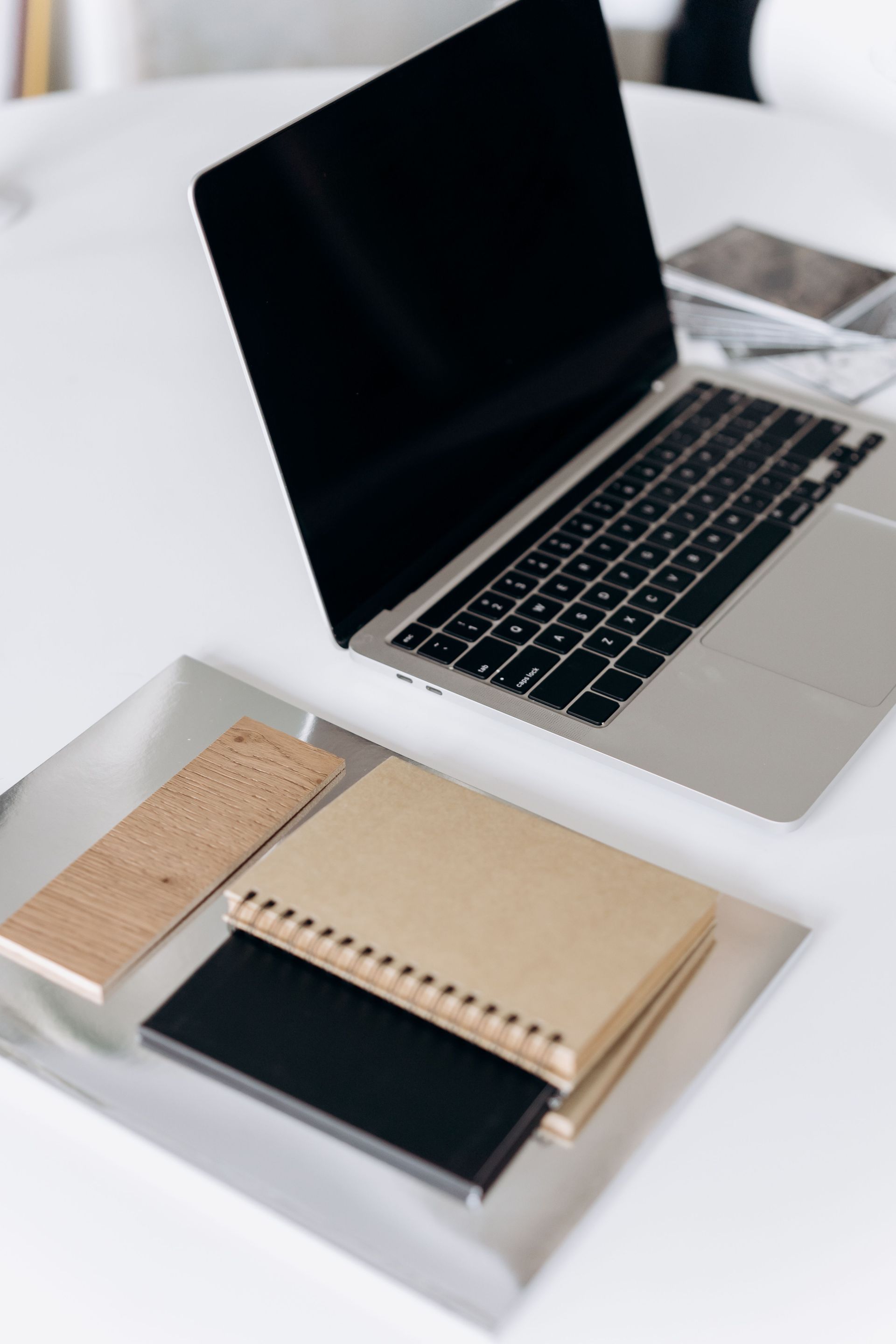 Hand writing in a notebook with a pen at a wooden desk