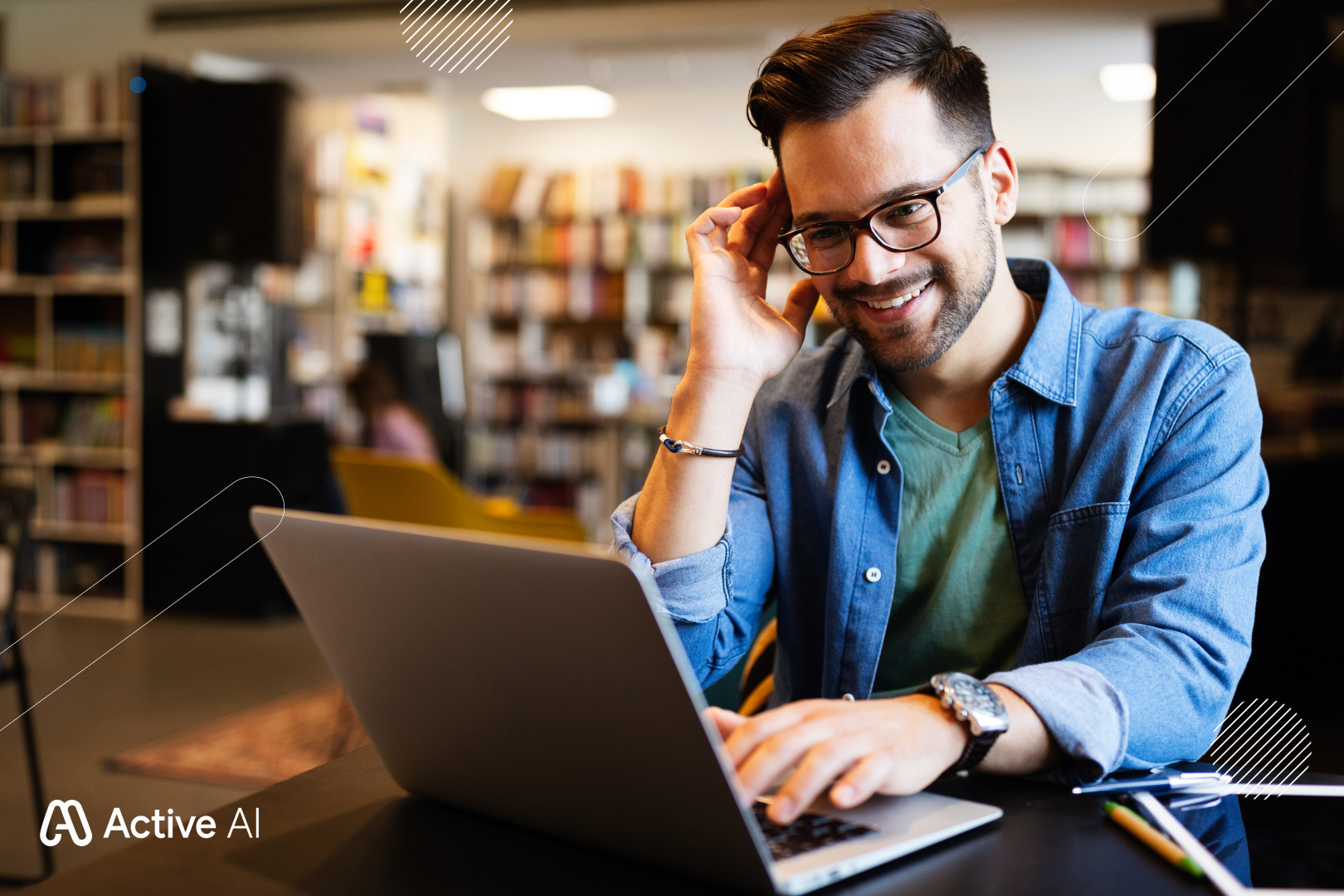 Man using laptop, smiling in library setting.
