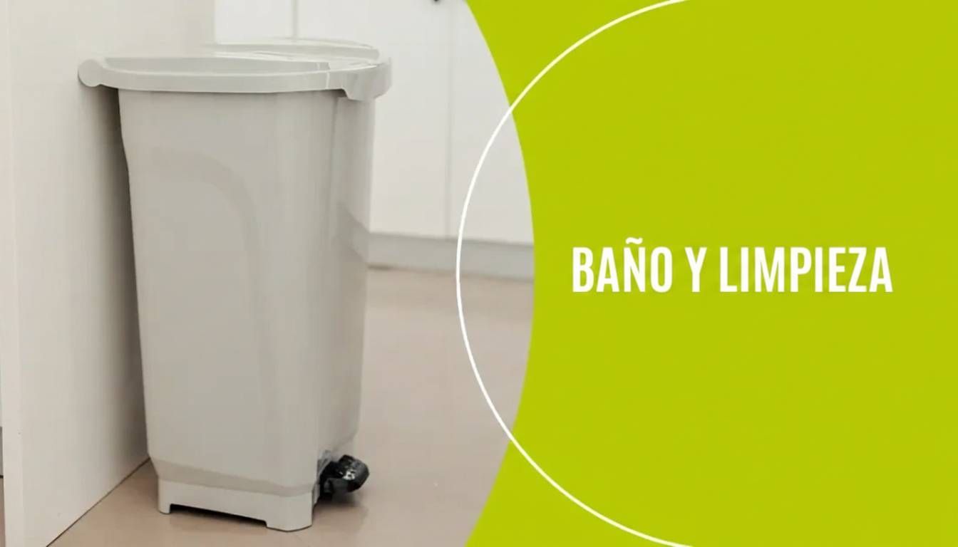 Papelera blanca con ruedas junto a la pared, con un panel verde que dice “BAÑO Y LIMPIEZA”.